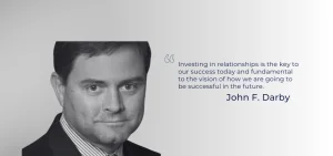 A black and white portrait of John F. Darby next to a quote about investing in relationships.