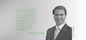 A man in a suit stands next to a quote in green text.