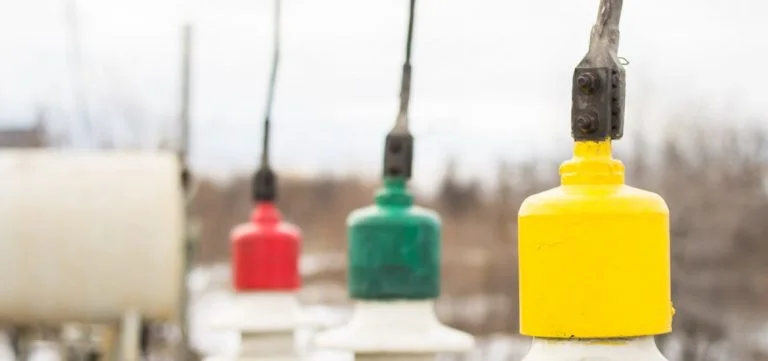 Three colored insulators, red, green, and yellow, are attached to wires.