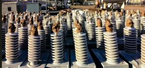 Rows of white, ribbed cylindrical objects sit on gray bases.