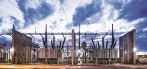 An electrical substation stands under a cloudy sky.