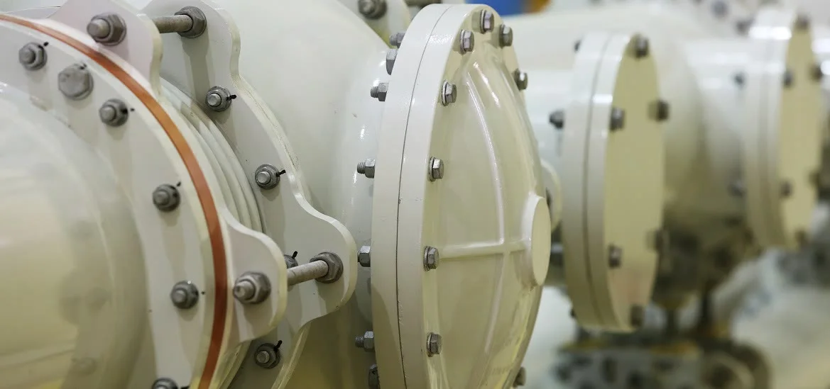 Large white industrial pipes and circular metal flanges.