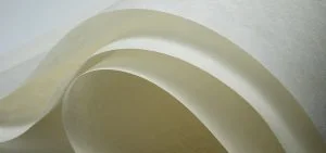 Curved layers of white paper create flowing waves.