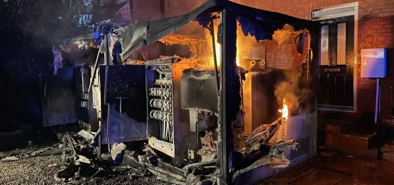 A metal structure is engulfed in flames and smoke.