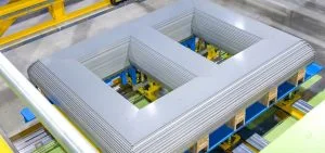 A large, rectangular, grey corrugated metal structure sits on a yellow and blue industrial platform.