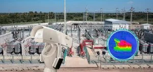 A white security camera overlooks an electrical substation.