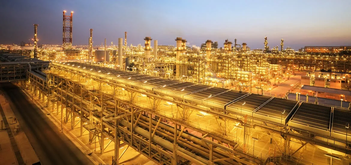 An industrial refinery complex is illuminated at dusk.