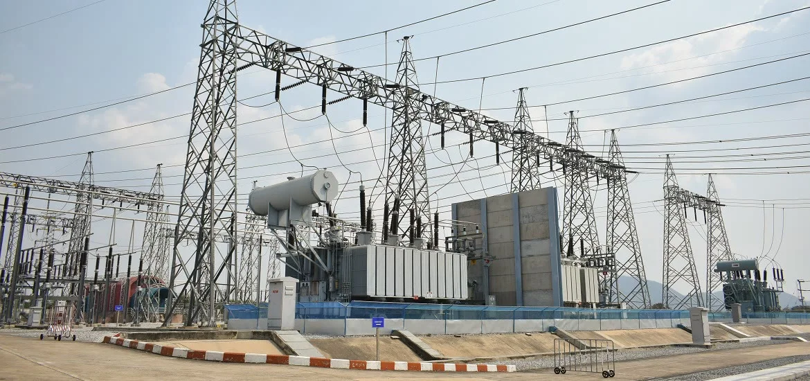 An electrical substation with power lines and large transformers.