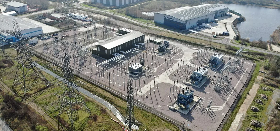 An aerial view of an electrical substation with power lines and equipment.