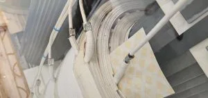 White wires and cables are coiled around a white circular object.