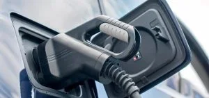 An electric vehicle charging cable is plugged into a car.