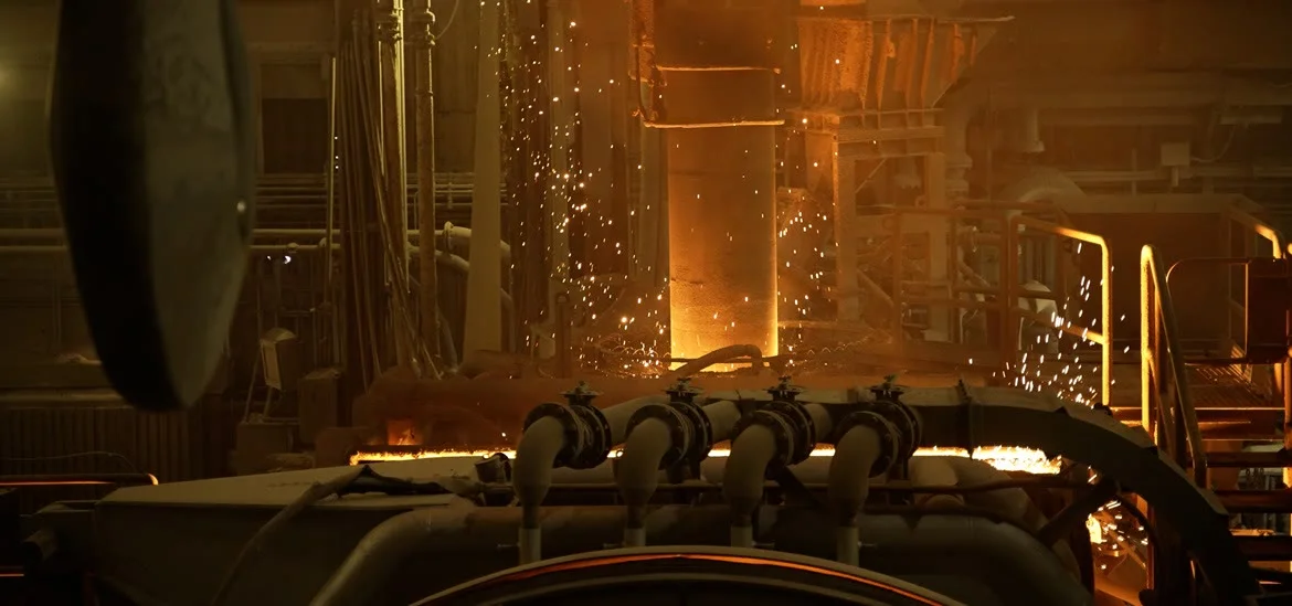 Sparks fly from industrial machinery in a dimly lit factory setting.