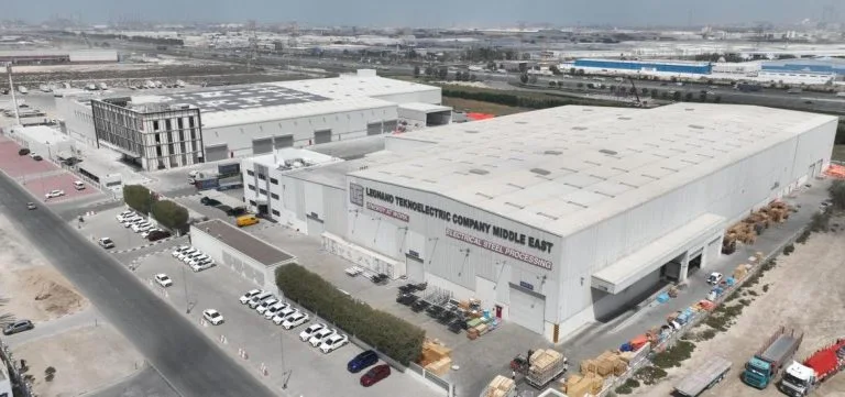 An aerial view of a large industrial warehouse complex with several parked vehicles and trucks.