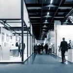 People walk through a modern indoor exhibition space.