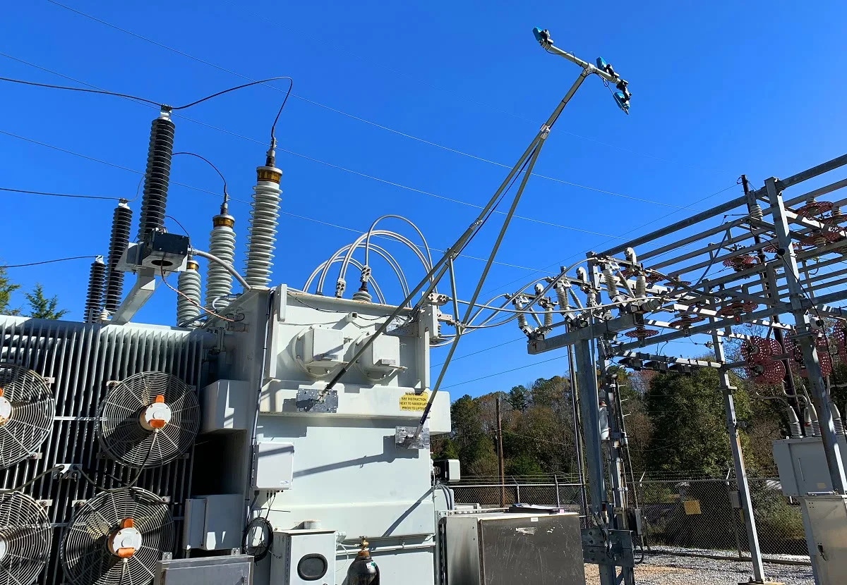 Electrical equipment and power lines stand against a clear blue sky.