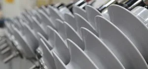 Rows of white plates are stacked closely together.