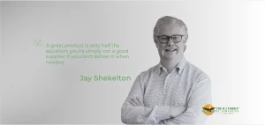 A man with gray hair and glasses smiles with his arms crossed next to a quote.
