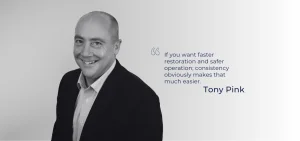 A smiling man in a suit stands next to a quote.